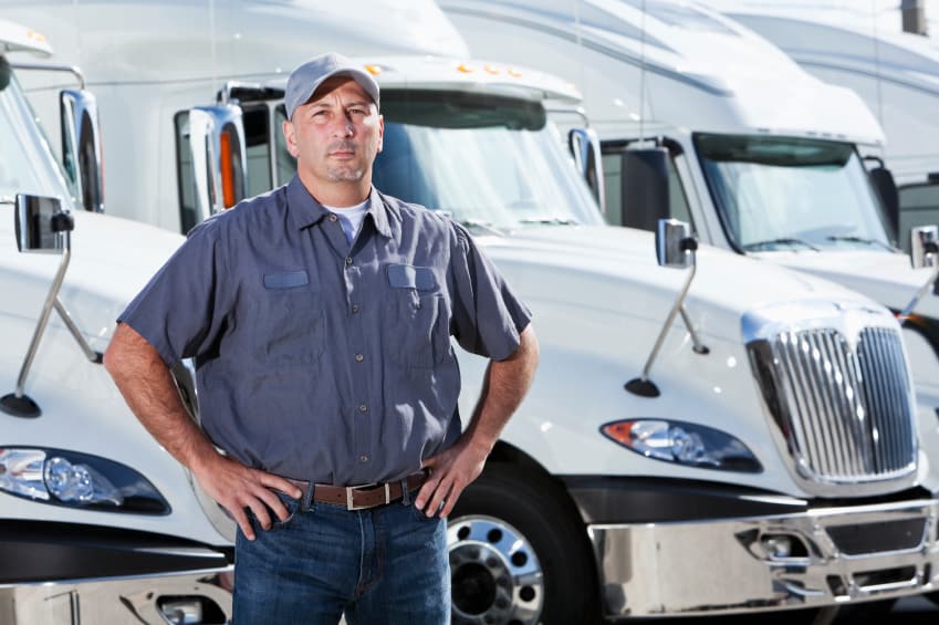 truck-driver-standing-in-front-of-big-rigs